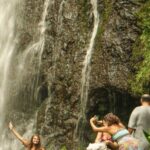 a group of people standing next to a waterfall