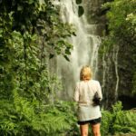 a person standing next to a waterfall