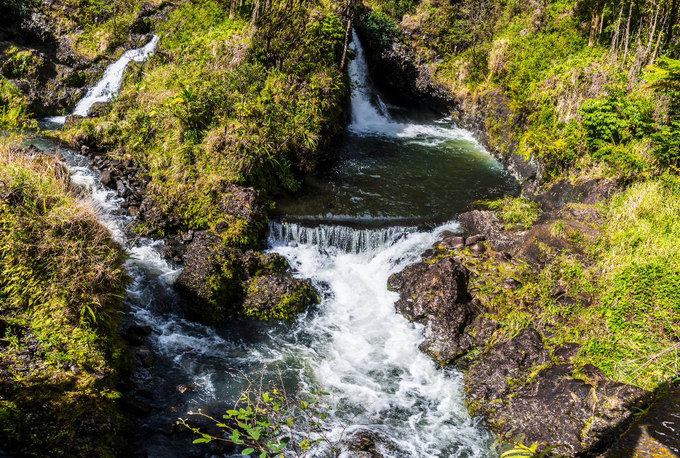 Hanawi Falls waterfall next to a river on the road to Hana in Maui