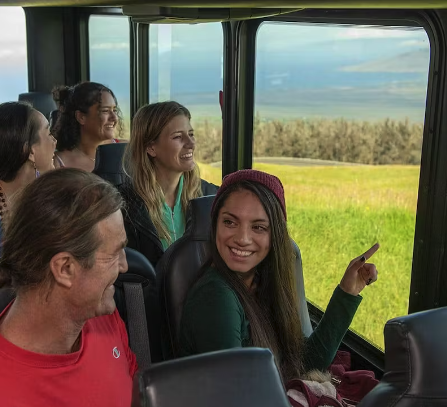 a group of people sitting in front of a window on a Hawaii tour bus in Maui